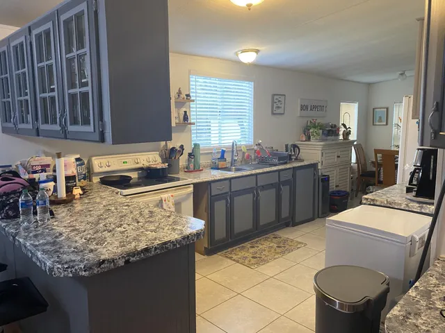 a kitchen with a stove sink and cabinets