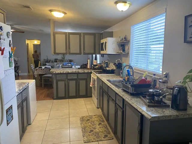 a kitchen with stainless steel appliances granite countertop a sink counter space cabinets and a large window