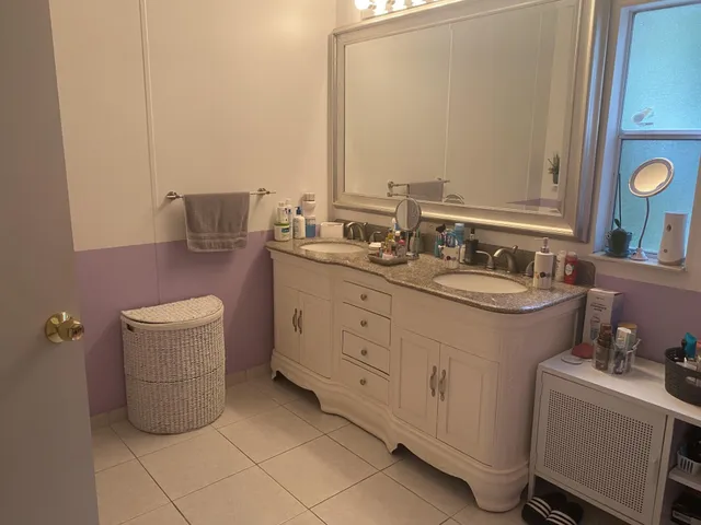 a bathroom with a double vanity sink a mirror and toilet