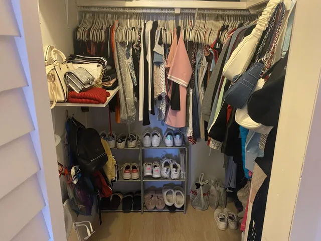 a view of walk in closet with clothes and shoes