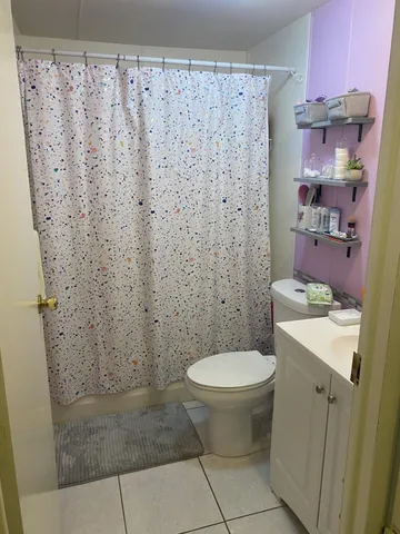 a bathroom with a sink a toilet and shower curtain
