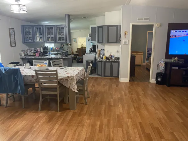 a kitchen with stainless steel appliances a dining table chairs and refrigerator