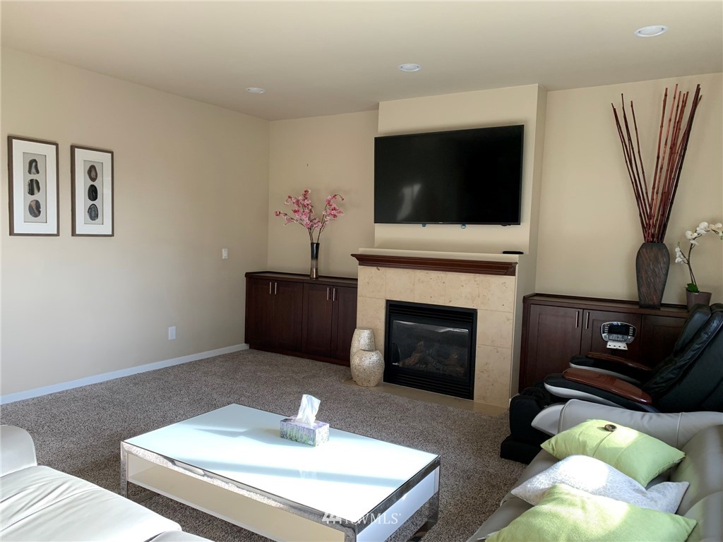 3627 Northeast 6th Street Renton, WA 98056 - Photo 13 of 40 a living room with furniture a flat screen tv and a fireplace