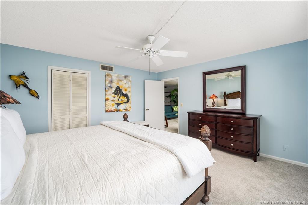 3100 Southeast Pruitt Road, Unit G205 Port St. Lucie, FL 34952 - Photo 16 of 29 a bedroom with a bed and a dresser
