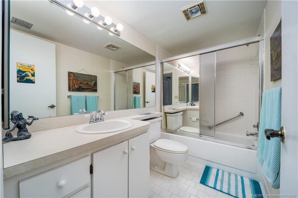 3100 Southeast Pruitt Road, Unit G205 Port St. Lucie, FL 34952 - Photo 21 of 29 a bathroom with a sink a toilet a mirror and shower