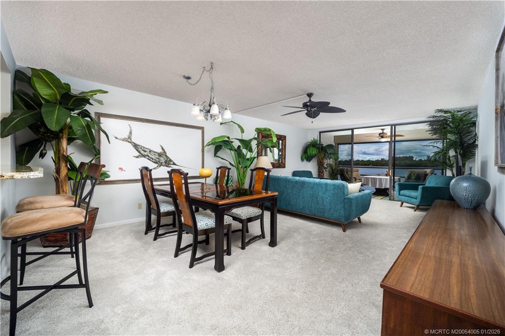 3100 Southeast Pruitt Road, Unit G205 Port St. Lucie, FL 34952 - Photo 6 of 29 a living room with furniture and a chandelier