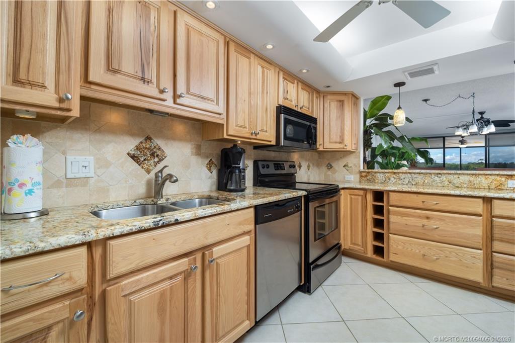 3100 Southeast Pruitt Road, Unit G205 Port St. Lucie, FL 34952 - Photo 9 of 29 a kitchen with granite countertop cabinets stainless steel appliances and a sink