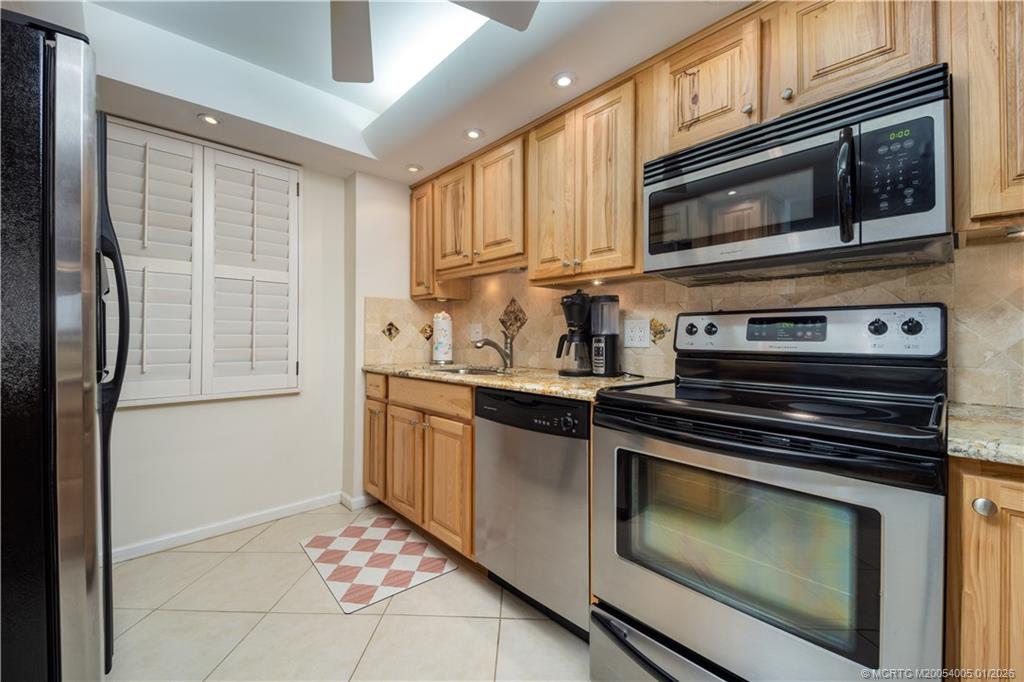 3100 Southeast Pruitt Road, Unit G205 Port St. Lucie, FL 34952 - Photo 10 of 29 a kitchen with stainless steel appliances granite countertop a stove microwave and cabinets