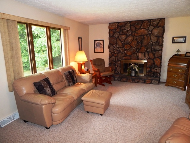 7560 Swanson Road Roscoe, IL 61073 - Photo 14 of 25 a living room with furniture a fireplace and a large window