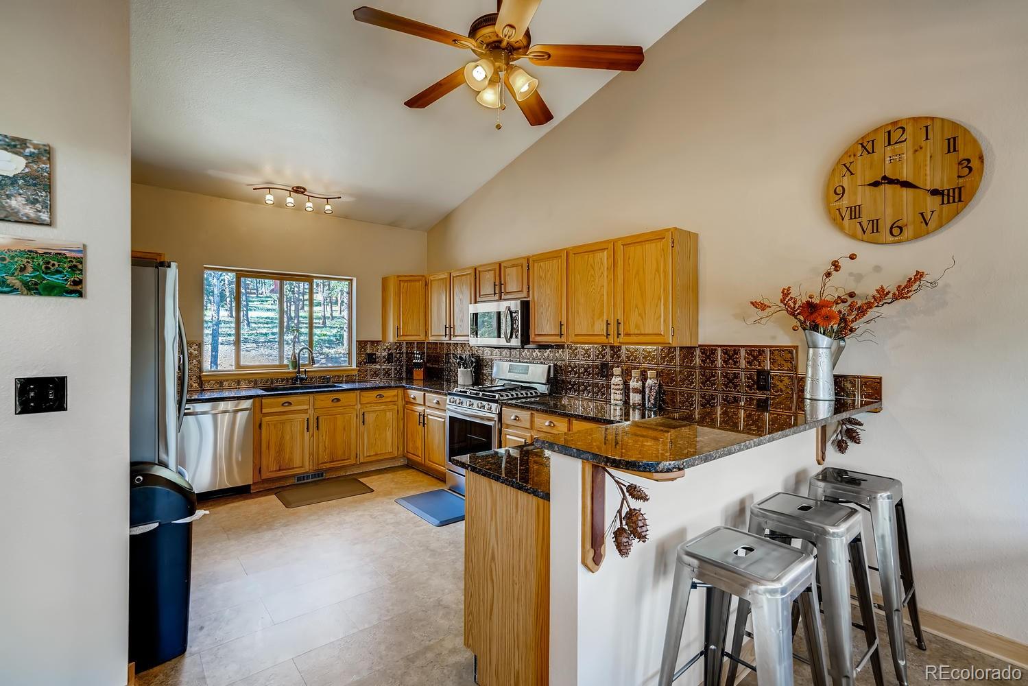 317 Conestoga Road Bailey, CO 80421 - Photo 8 of 40 a kitchen that has a lot of cabinets and wooden floor
