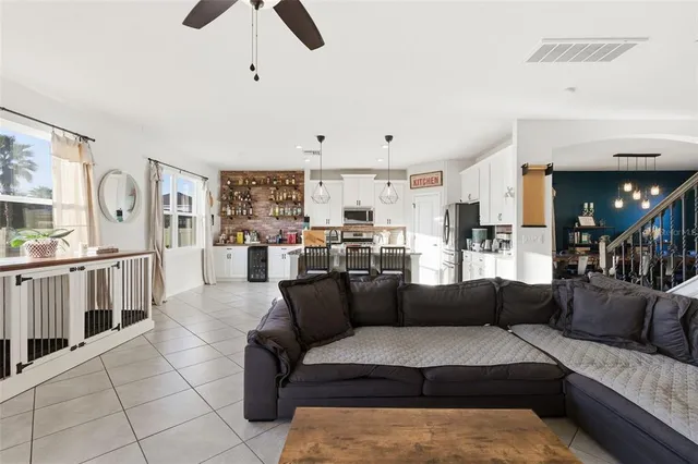 a living room with furniture kitchen view and a flat screen tv