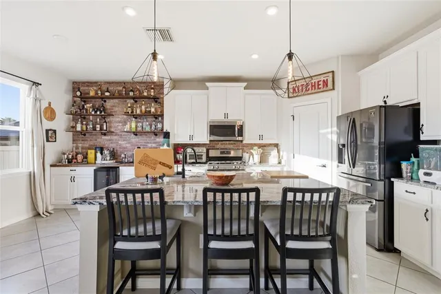 a kitchen with stainless steel appliances kitchen island granite countertop a sink and cabinets
