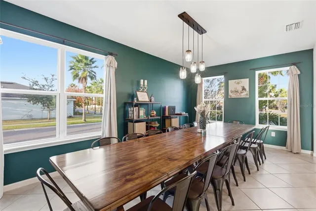 a dining room with furniture a chandelier and wooden floor