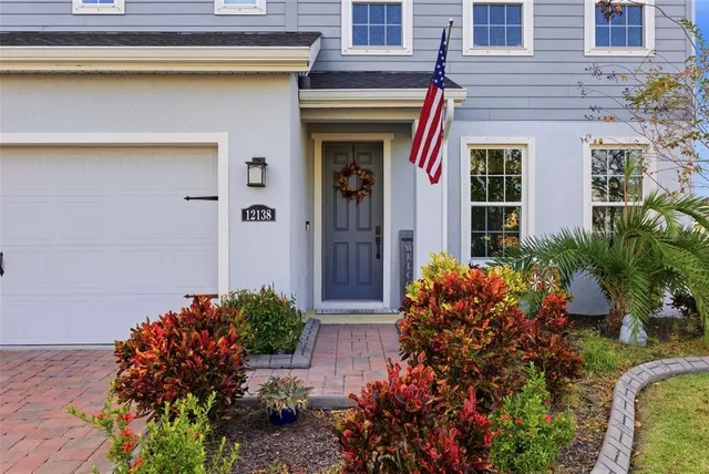a front view of a house with a garden and plants