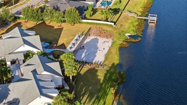 an aerial view of residential houses with outdoor space and ocean view