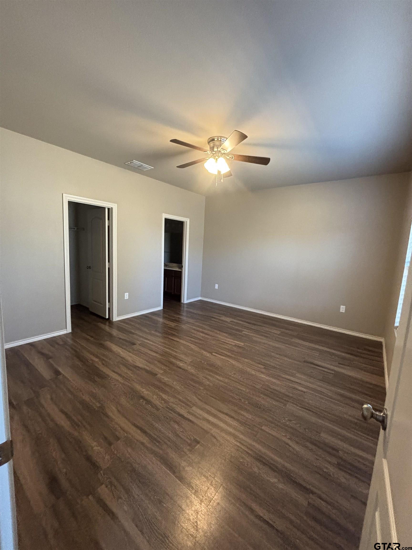 17440 Stacy Street Lindale, TX 75771 - Photo 4 of 9 a view of an empty room with wooden floor and a ceiling fan