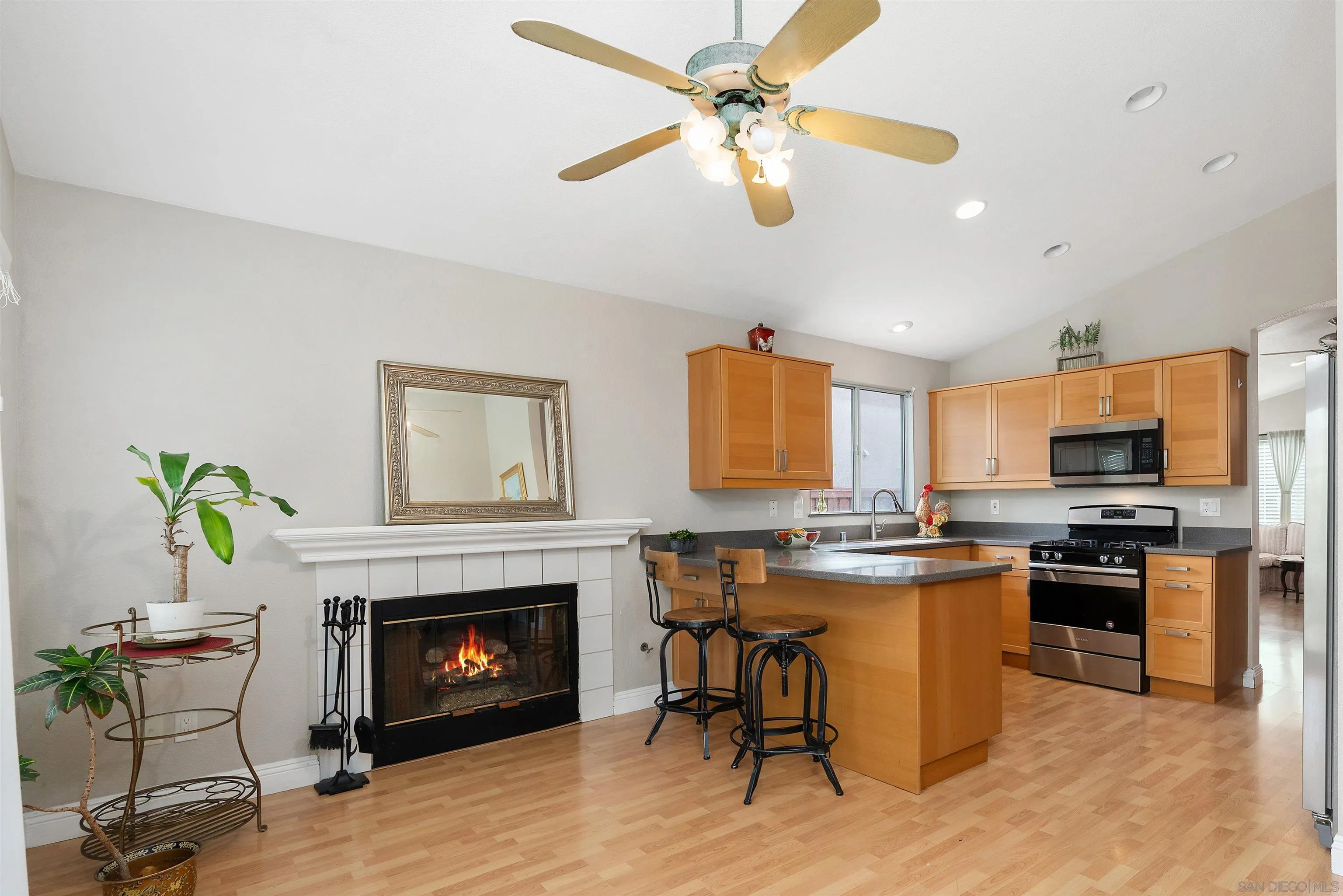 43070 Corte Salamanca Temecula, CA 92592 - Photo 10 of 30 a kitchen with stainless steel appliances granite countertop a stove top oven a sink a dining table and chairs with wooden floor