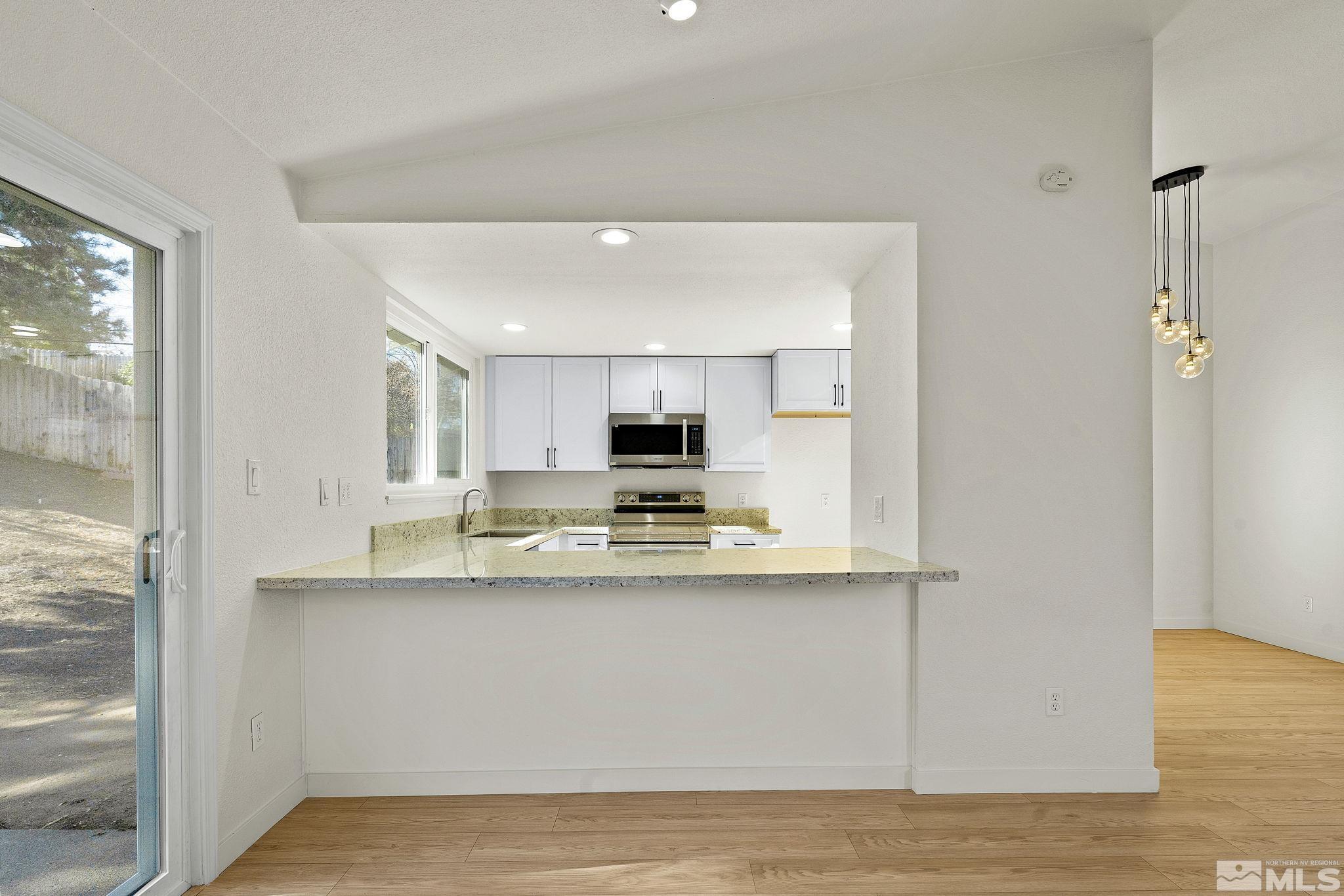 1720 Kings Row Reno, NV 89503 - Photo 15 of 39 a view of a kitchen with kitchen island a sink wooden floor and a refrigerator