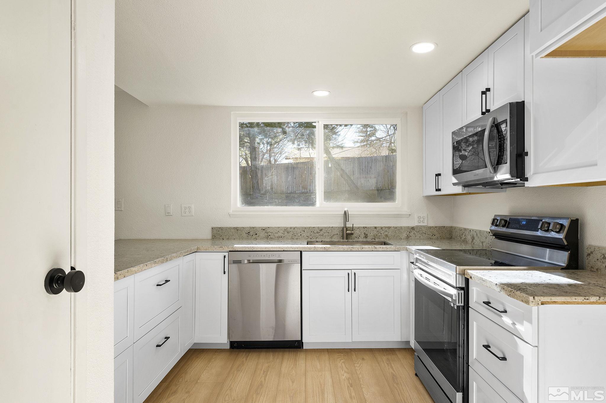 1720 Kings Row Reno, NV 89503 - Photo 16 of 39 a kitchen with white cabinets appliances and a window