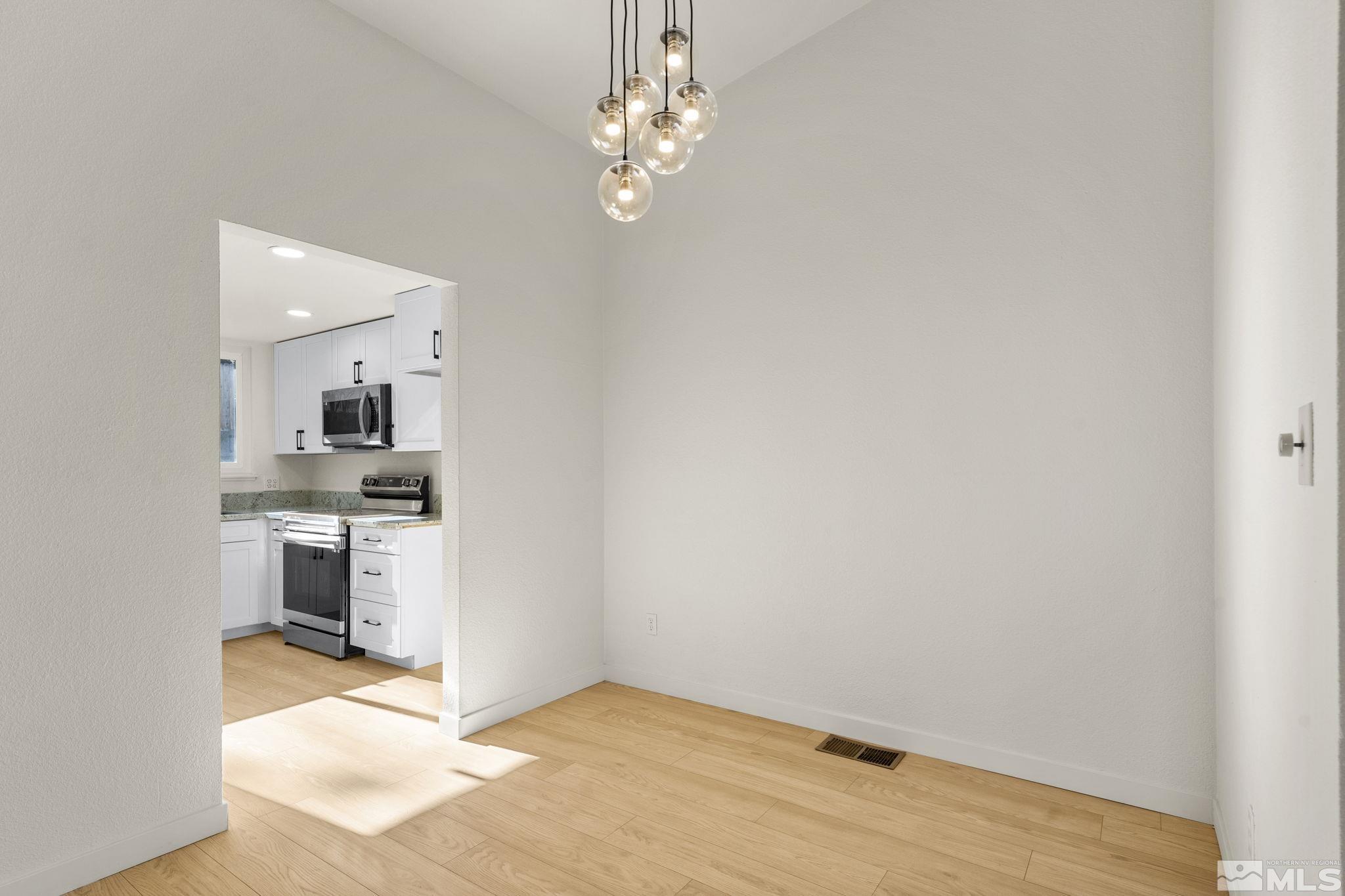 1720 Kings Row Reno, NV 89503 - Photo 19 of 39 wooden floor in an empty room with a kitchen