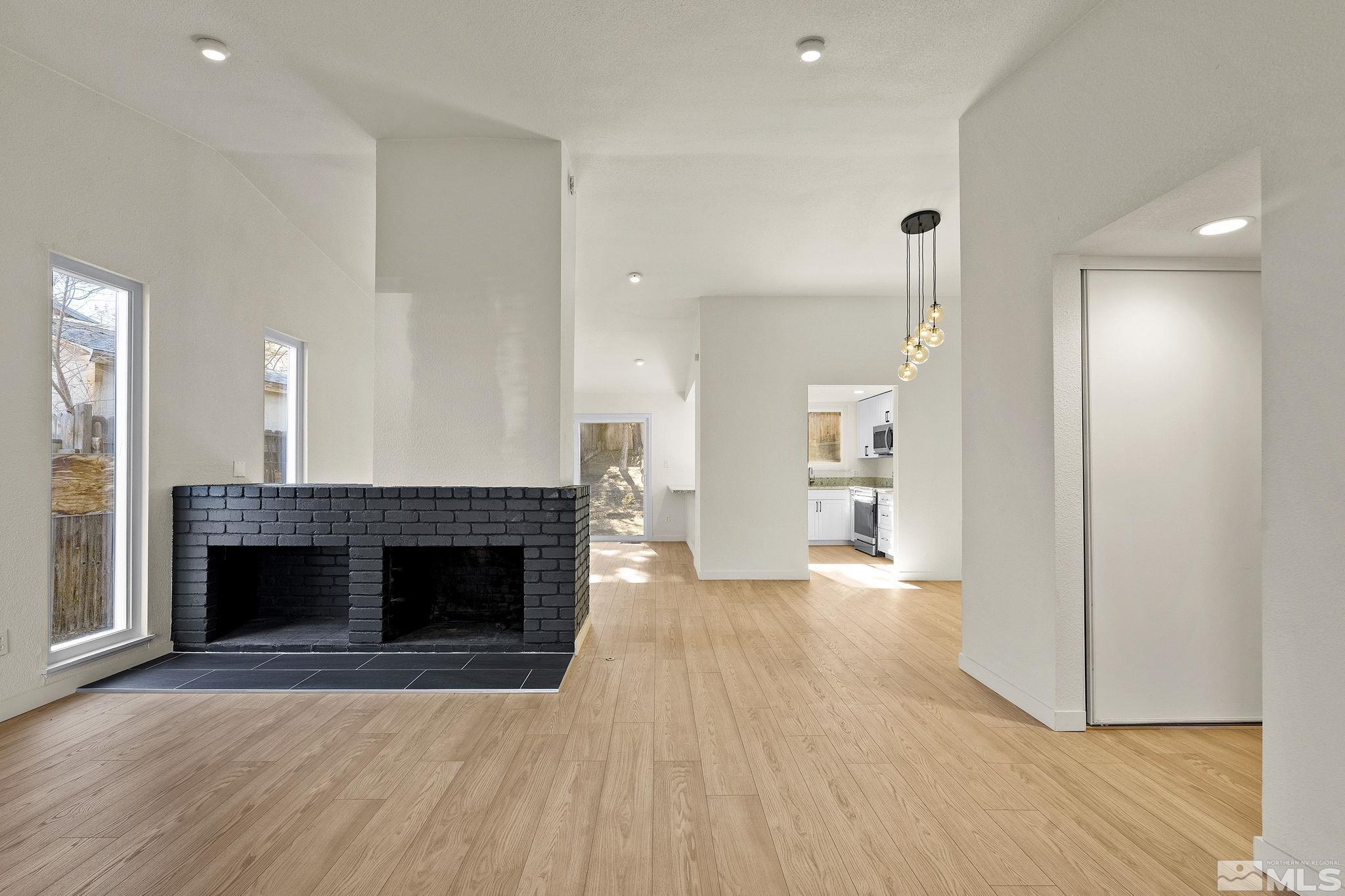 1720 Kings Row Reno, NV 89503 - Photo 9 of 39 an empty room with wooden floor fireplace and windows