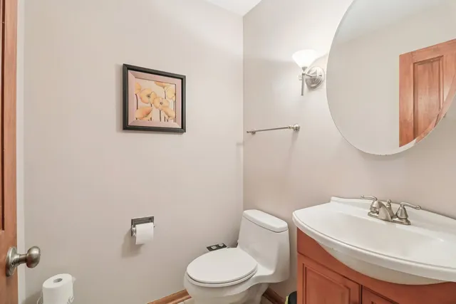 a bathroom with a toilet a sink and mirror