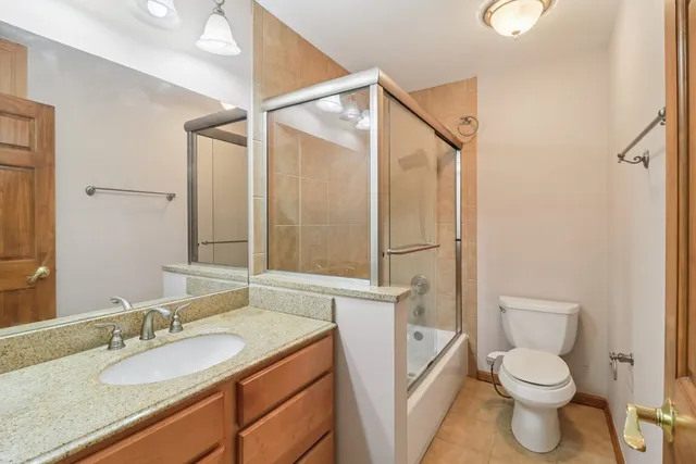 a bathroom with a granite countertop sink toilet and shower