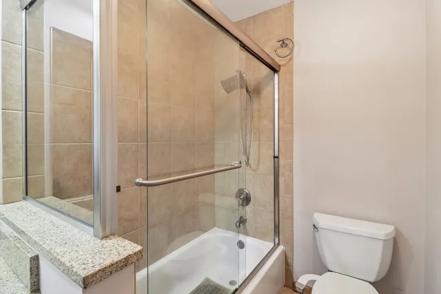 a bathroom with a granite countertop sink toilet and shower