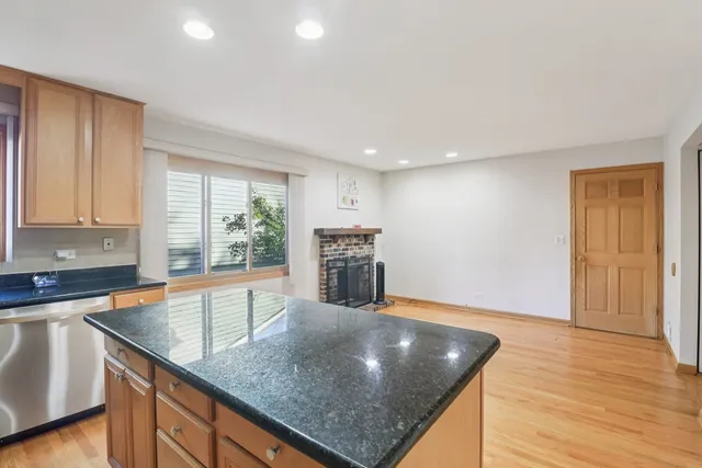 a kitchen with stainless steel appliances granite countertop a sink a stove and a wooden cabinets