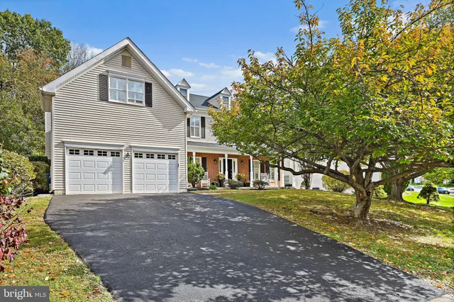 a front view of a house with a yard and trees