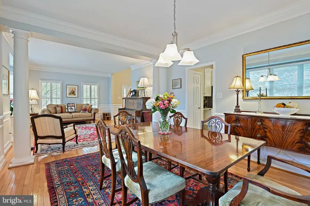 a view of a dining room with furniture a chandelier and wooden floor