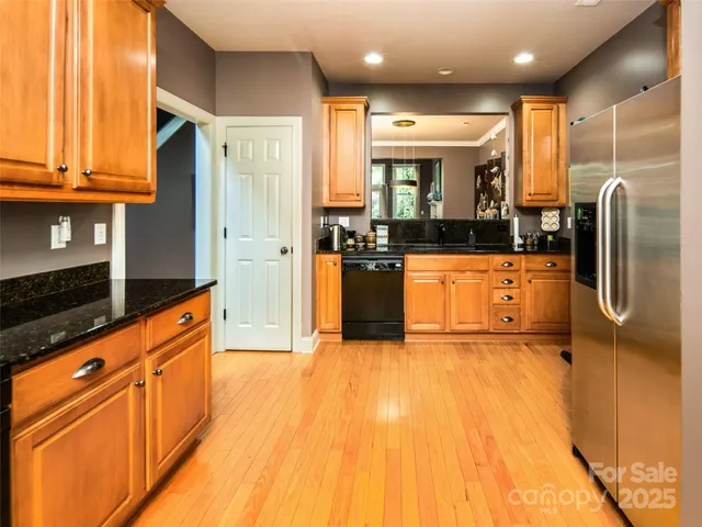 a kitchen with stainless steel appliances granite countertop a refrigerator a sink and a stove