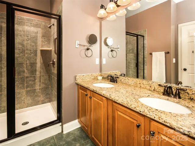 a bathroom with a granite countertop sink mirror and a shower