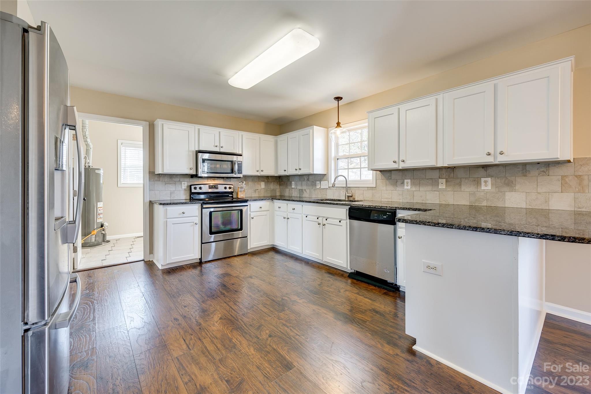 573 Strathclyde Way Rock Hill, SC 29730 - Photo 11 of 21 a kitchen with granite countertop wooden floors stainless steel appliances and sink