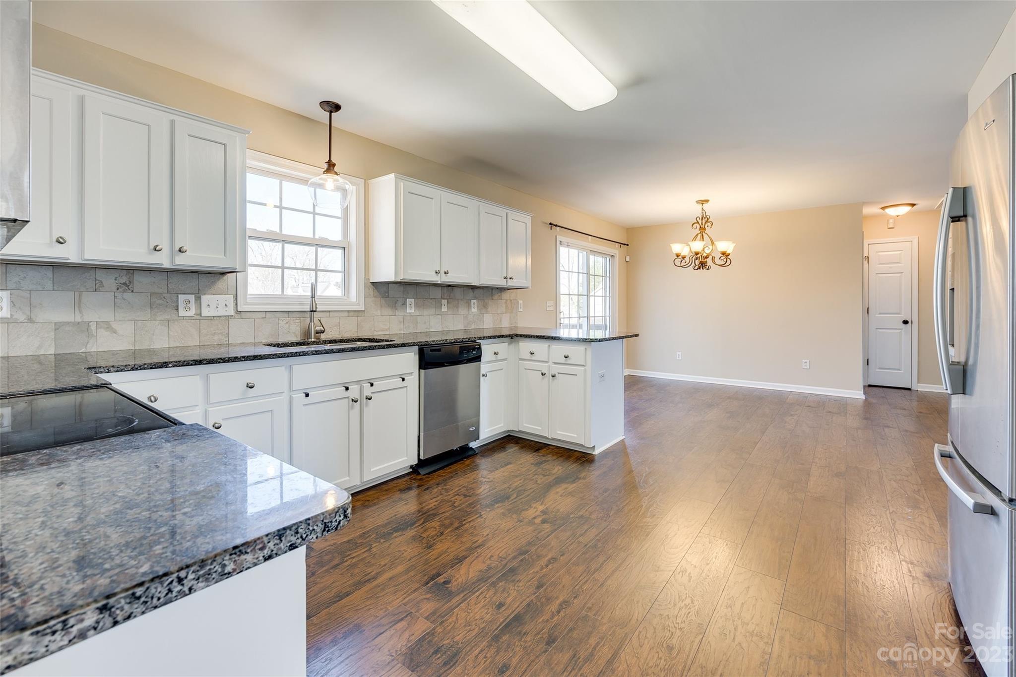 573 Strathclyde Way Rock Hill, SC 29730 - Photo 10 of 21 a kitchen with stainless steel appliances granite countertop a sink dishwasher a stove and white cabinets with wooden floor