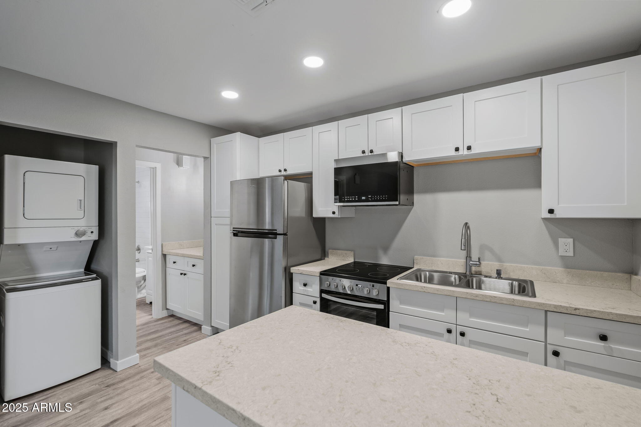 1940 West Amelia Avenue, Unit 1942 5 Phoenix, AZ 85015 - Photo 11 of 18 a kitchen with white cabinets and stainless steel appliances