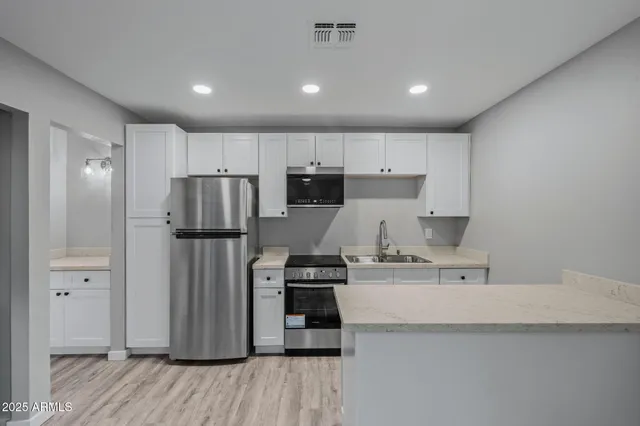 a bathroom with a granite countertop toilet and a sink