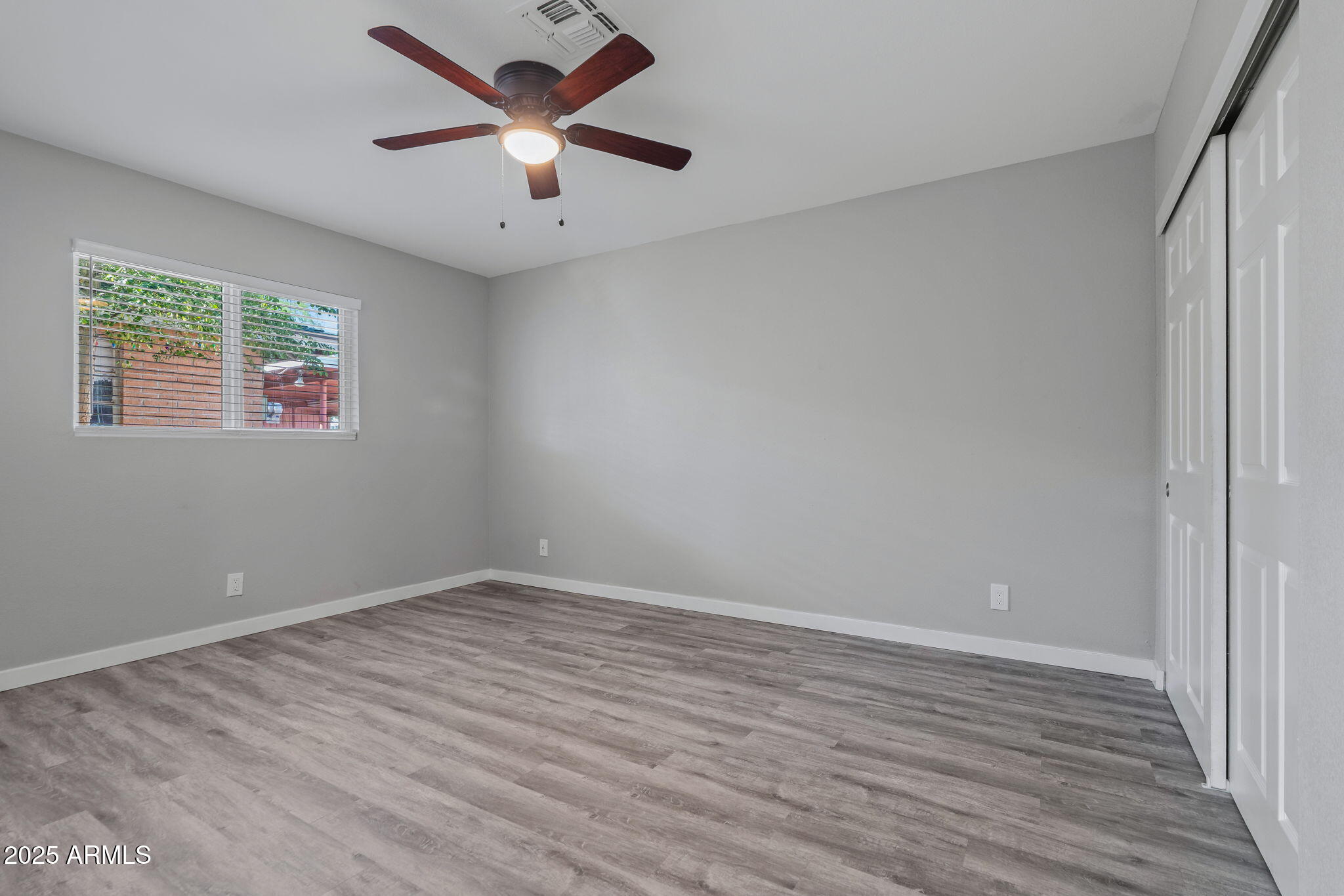1940 West Amelia Avenue, Unit 1942 5 Phoenix, AZ 85015 - Photo 15 of 18 an empty room with wooden floor and windows