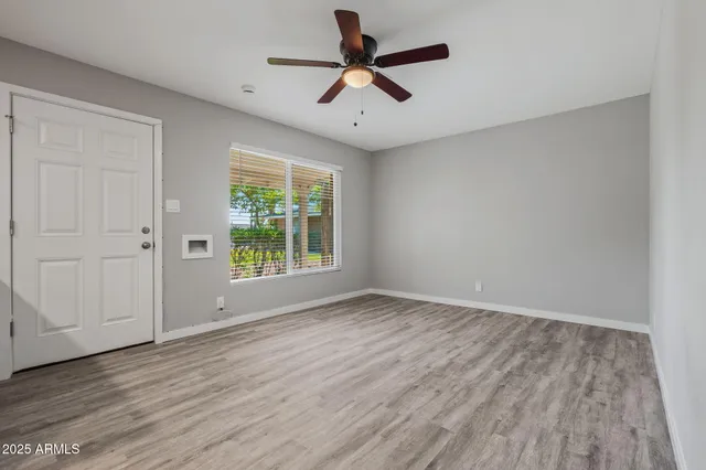 a view of room with window ceiling fan and hardwood floor