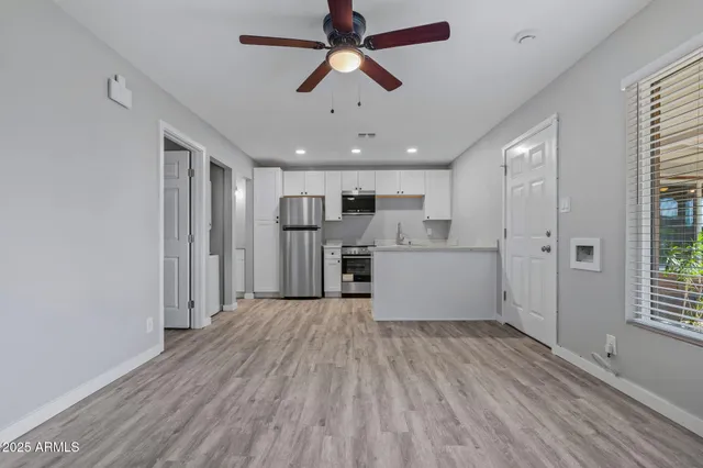 a view of a kitchen with a sink refrigerator and a window