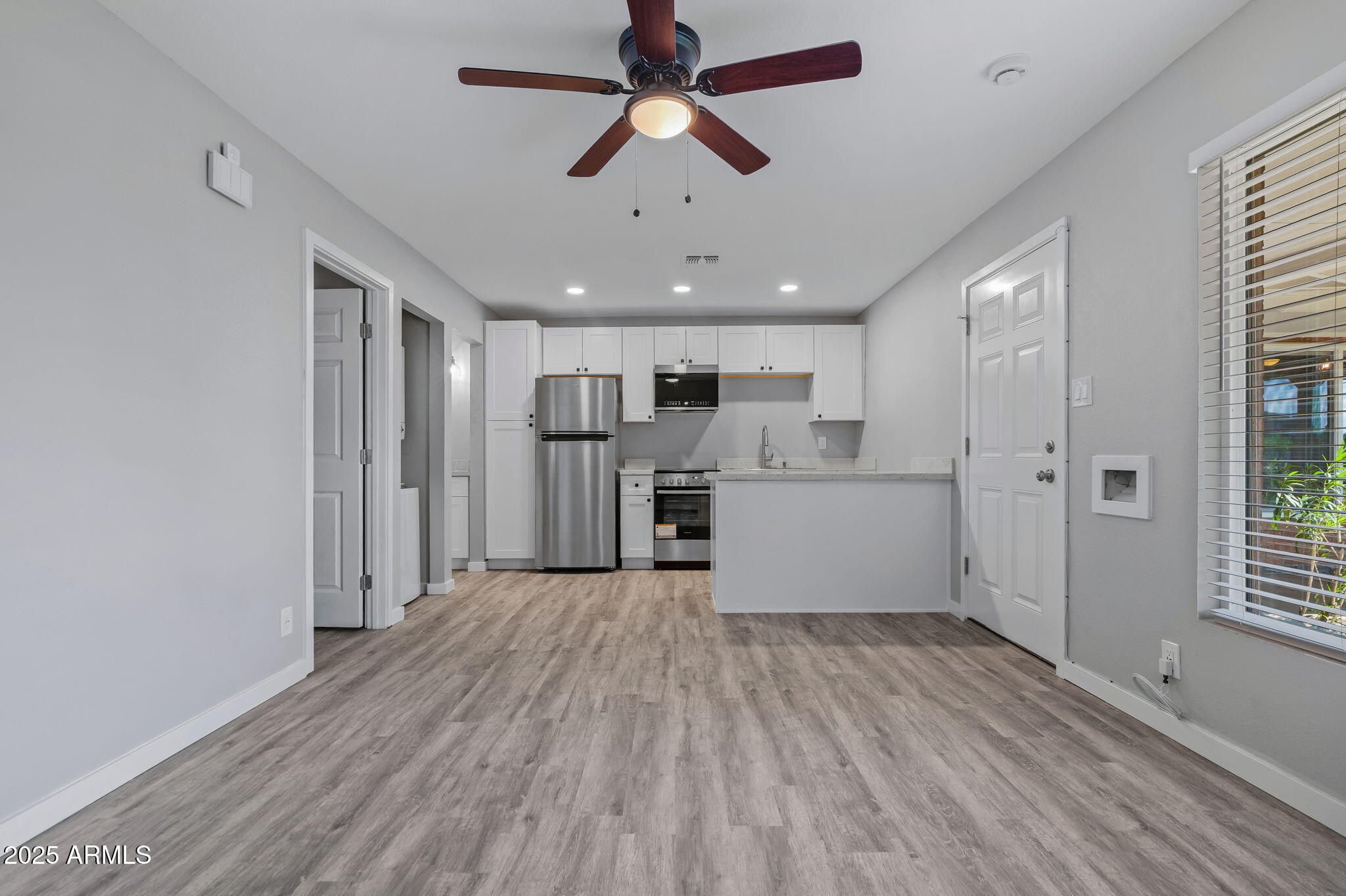 1940 West Amelia Avenue, Unit 1942 5 Phoenix, AZ 85015 - Photo 9 of 18 a view of a kitchen with a refrigerator a ceiling fan and wooden floor