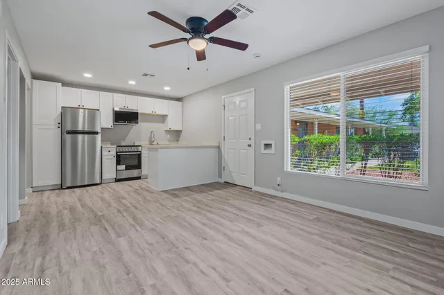 a kitchen with white cabinets and stainless steel appliances