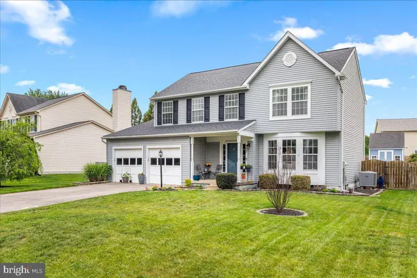 a front view of a house with a yard and trees