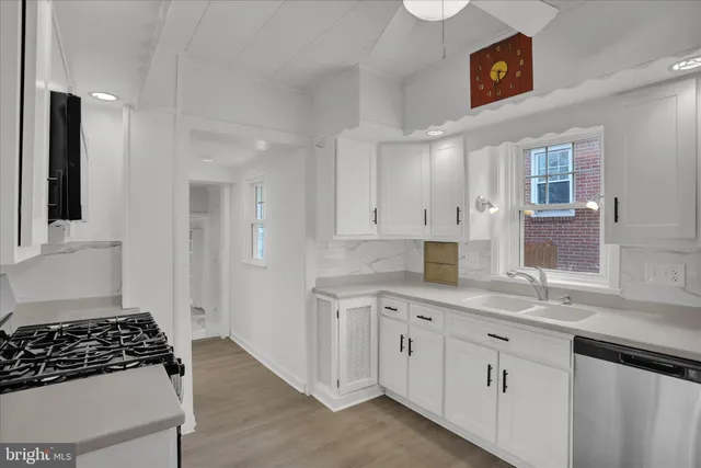 a kitchen with white cabinets and appliances