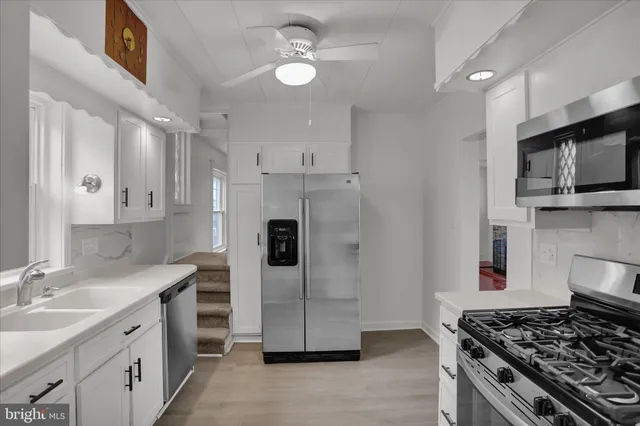 a kitchen with stainless steel appliances granite countertop a stove a sink and a refrigerator
