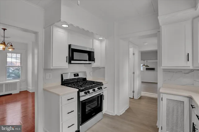 a kitchen with stainless steel appliances a white stove top oven and a refrigerator