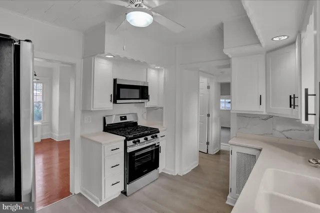 a kitchen with granite countertop a sink appliances and cabinets