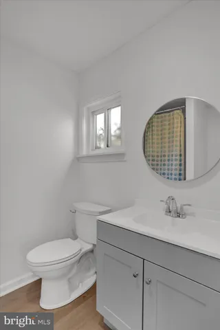 a bathroom with a toilet a sink and mirror