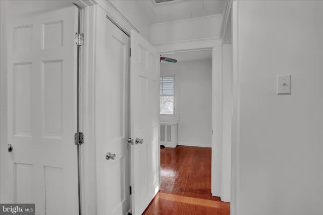 a view of a hallway with wooden floor and staircase