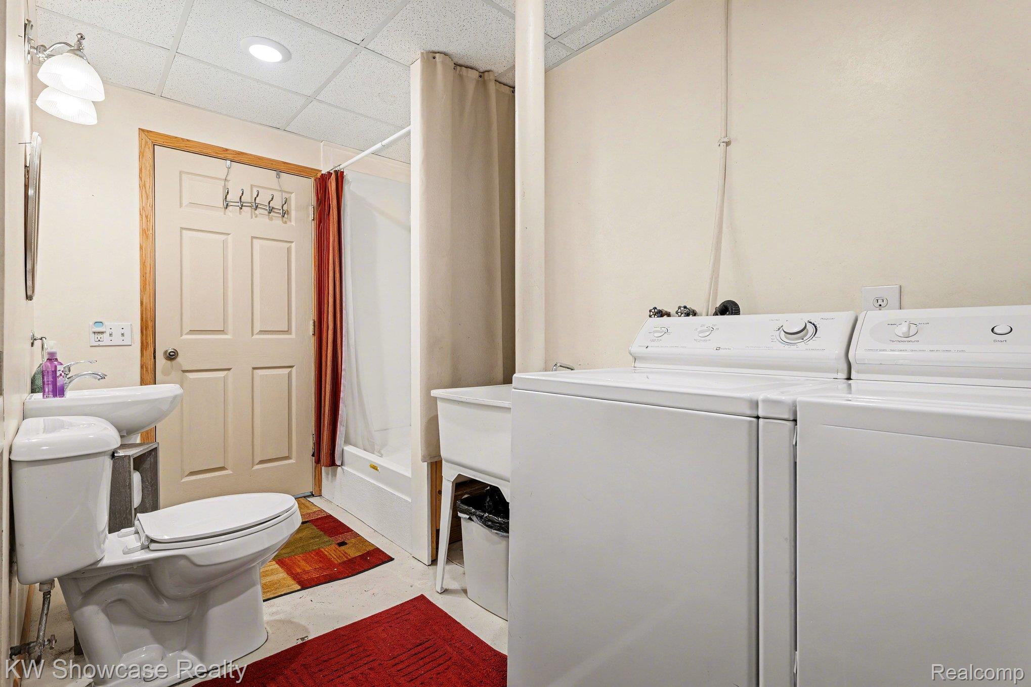 1951 East Kneeland Road Fairview, MI 48621 - Photo 26 of 46 Laundry area featuring a drop ceiling, concrete flooring, and separate washer and dryer